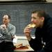 Pioneer Head Coach Rex Stanczak talks to his team as they eat pizza after defeating Saline 58-53 on Friday, Feb. 1. Daniel Brenner I AnnArbor.com